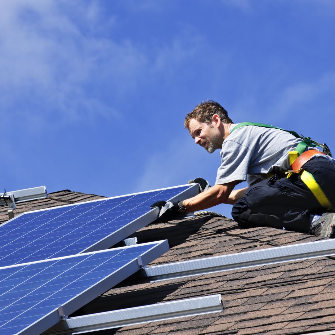 man installing solar system on roof